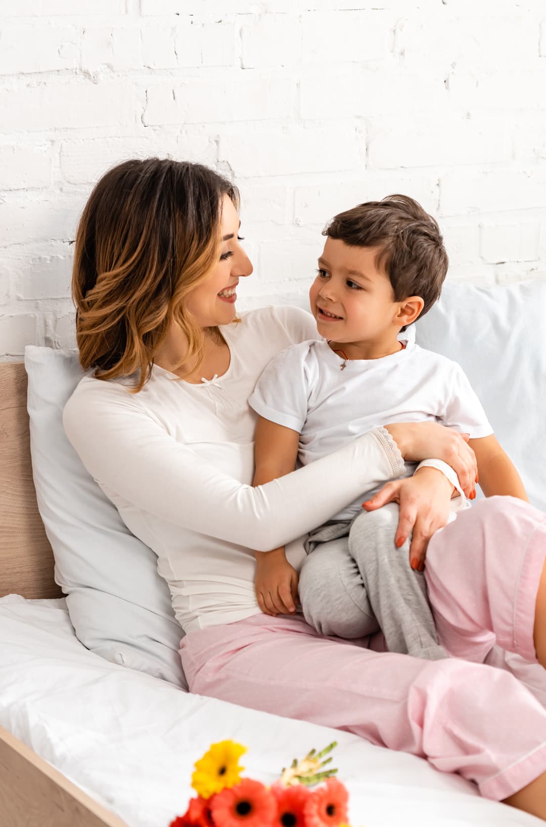 A mother and her young son smiling at each other
